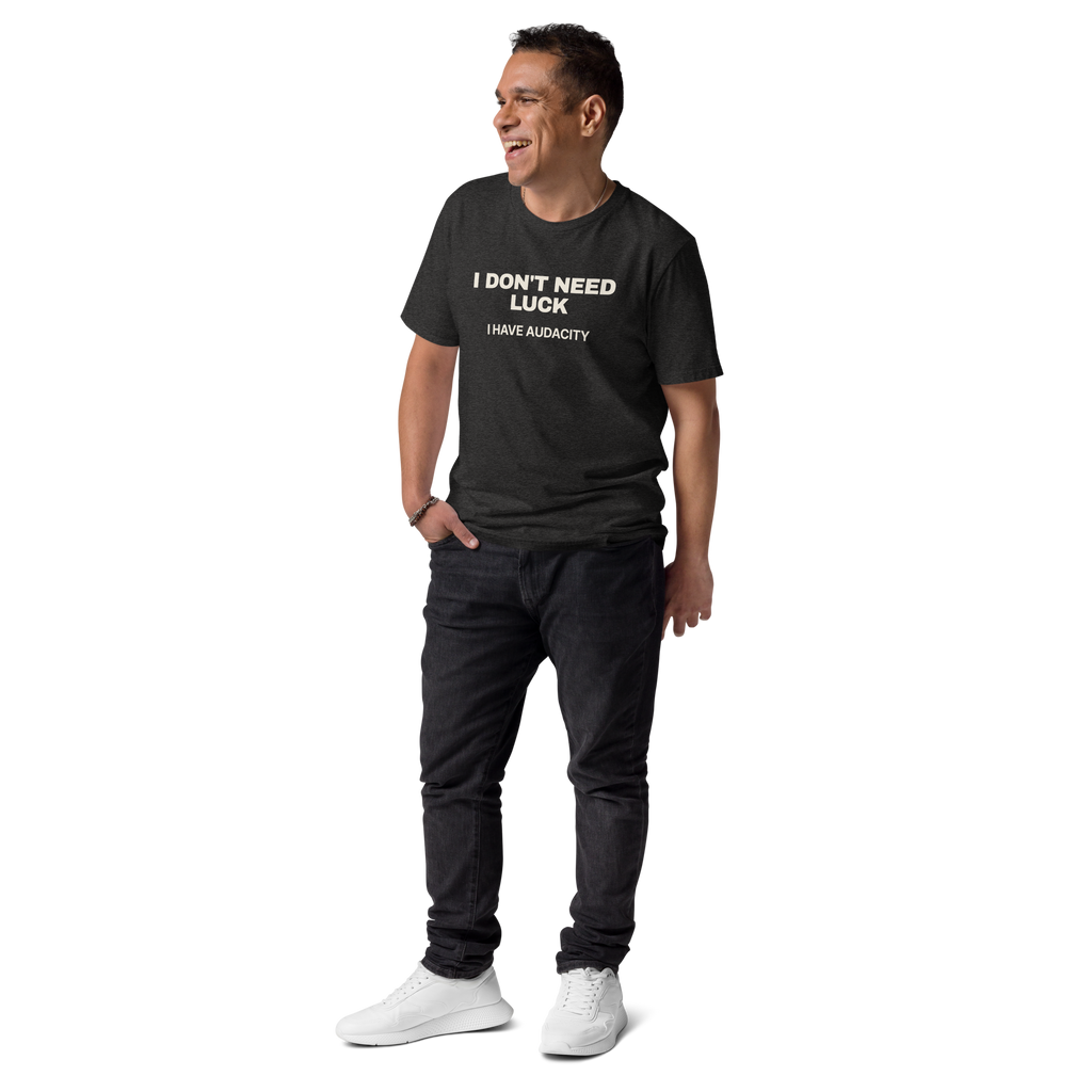 Man wearing the I Don’t Need Luck. I Have Audacity T-shirt in dark heather grey, front view